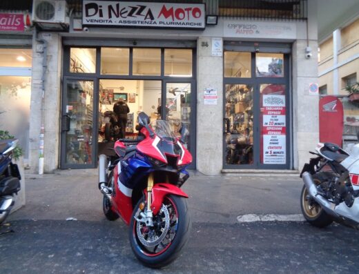 Di Nezza Moto S.R.L., negozio di vendita e assistenza plurimarche di moto, accessori e ricambi. In primo piano una moto sportiva rossa e blu.