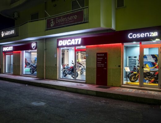 Ducati Cosenza concessionaria ufficiale: vetrina notturna con esposizione di moto Ducati, vendita accessori e ricambi originali, servizio assistenza e officina specializzata.