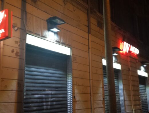 Facciata notturna di DV Moto, con insegna luminosa Honda Service. Negozio di accessori e servizi per motociclisti.