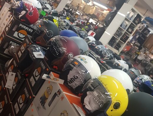 Assortimento di caschi per moto in vendita da Easy Motors SRL, negozio di accessori e abbigliamento per motociclisti, con confezioni colorate.