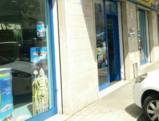 Elleti Travel di Lucio Telesca: vetrina dell'agenzia viaggi con insegna gialla e vetrofanie promozionali di viaggi in Asia e Malesia.