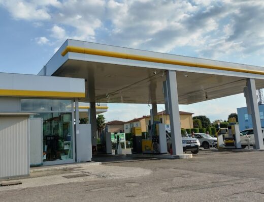 Stazione Eni con autolavaggio Pratesi, con auto in fila per il rifornimento carburante e il logo Eni ben visibile.