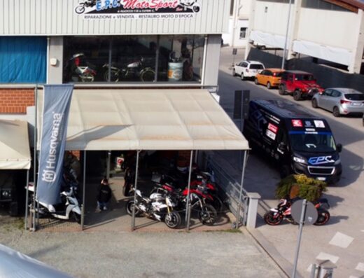 Veduta esterna di EPC Motosport SNC, negozio di riparazione, vendita e restauro di moto d'epoca. In esposizione diverse motociclette e accessori.