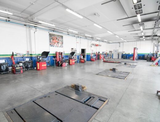 Interno dell'officina Euromaster Cosmo Gomme a San Salvo, con attrezzature per la manutenzione di pneumatici e veicoli, inclusi sollevatori e banchi di lavoro.