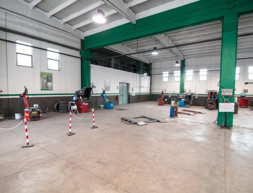 Interno dell'officina Euromaster F.lli Micheli, con attrezzature per la riparazione e manutenzione di pneumatici e veicoli, inclusi ponti sollevatori e macchinari specifici.