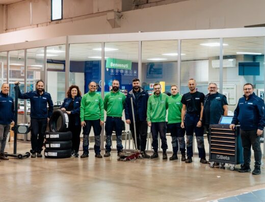 Team di Euromaster Imbimbo Gomme posa con pneumatici e attrezzature da officina per moto, offrendo servizi professionali.