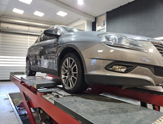 Auto grigia su ponte elevatore presso Euromaster M.G.DI MOSSUCCA STEFANO &C. SAS, per manutenzione pneumatici e servizi auto.