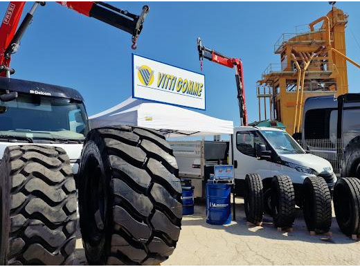 Esposizione di pneumatici Euromaster Vitti Gomme per camion e veicoli commerciali, con gru, furgoni e cartello del rivenditore.