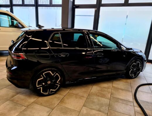 Auto nera Volkswagen Golf in un autolavaggio Evolution Car Wash, dettaglio dei cerchi in lega e carrozzeria lucida dopo il lavaggio.