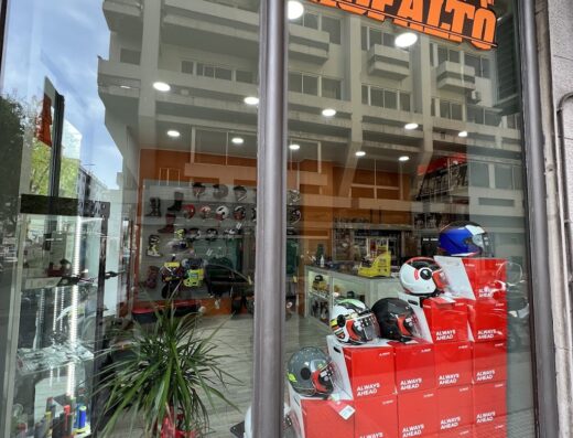 Vetrina del negozio Fango e Asfalto moto, con esposizione di caschi e accessori per motociclisti, abbigliamento tecnico e protezioni per la sicurezza su strada e offroad.