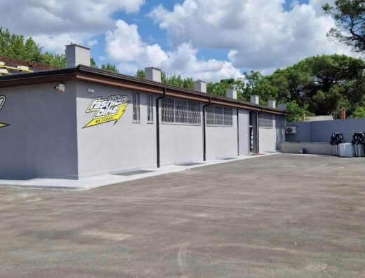 Edificio di Fashion Bike Off Road, negozio specializzato in moto da cross e accessori per motociclisti, con ampio parcheggio esterno.