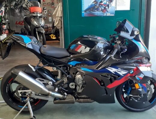 Primo piano di una moto BMW M 1000 RR con dettagli rossi, blu e neri in esposizione da FB Racing S.a.s., concessionario moto e accessori.
