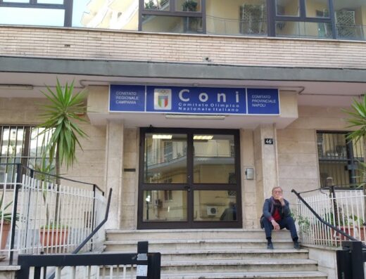 Ingresso della sede CONI (Comitato Olimpico Nazionale Italiano) con un uomo seduto sui gradini. Federazione Motociclistica Italiana.