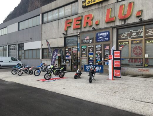 Fer.Lu. srl: negozio di moto con diverse moto esposte all'esterno, insegne di marchi come Yamaha, Michelin, Acerbis, Alpinestars e vendita accessori moto.