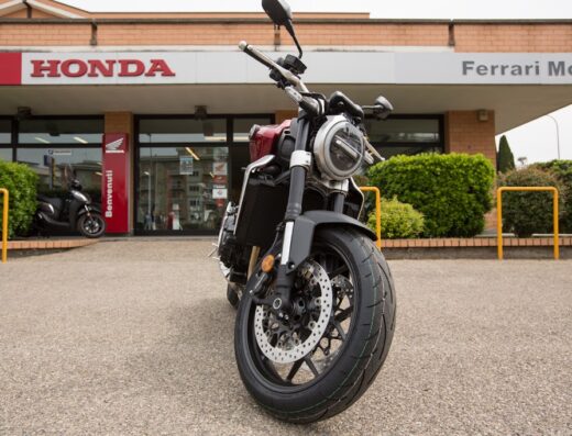 Primo piano di una moto Honda parcheggiata di fronte a Ferrari Moto, concessionario Honda. Servizi di vendita e riparazione moto.