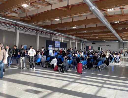 Folla di persone sedute alla Fiera di Treviglio; vista ampia dell'evento con visitatori e stand espositivi