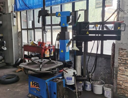 Immagine di un'attrezzatura professionale per il servizio di cambio gomme moto presso Filippi Service di Filippi Stefano, con smontagomme HPA e banner Toyo Tires.