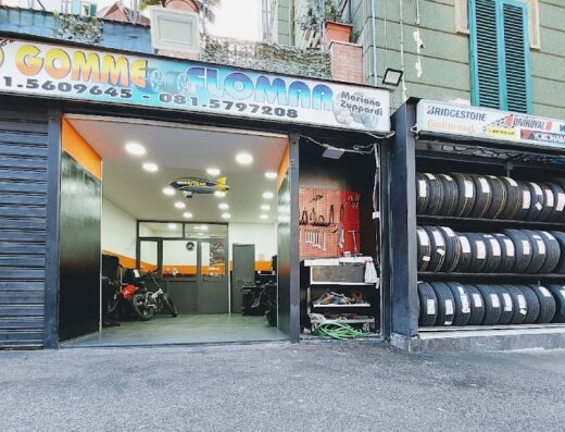 Flomar Gomme Sas Di Zuppardi Mario store front featuring motorcycle tires, service tools, and motorcycles inside the garage.