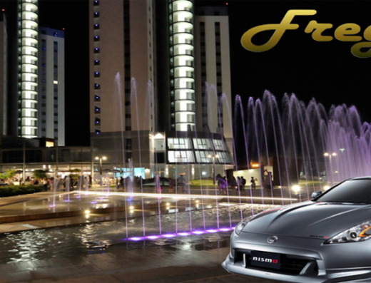 Auto sportiva Nissan Nismo grigia in primo piano con fontana illuminata e grattacieli sullo sfondo, logo Freguia in alto a destra.