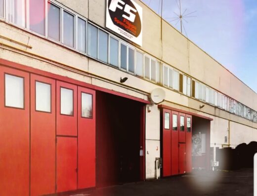 L'esterno dell'edificio FS Gomme, specializzato in servizi per pneumatici moto, con porte rosse e l'insegna del marchio visibile.