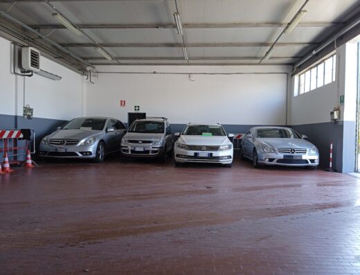 Quattro auto usate in vendita presso Future Car s.r.l.s., inclusi modelli Mercedes e Volkswagen, parcheggiate in un garage con segnaletica di sicurezza.