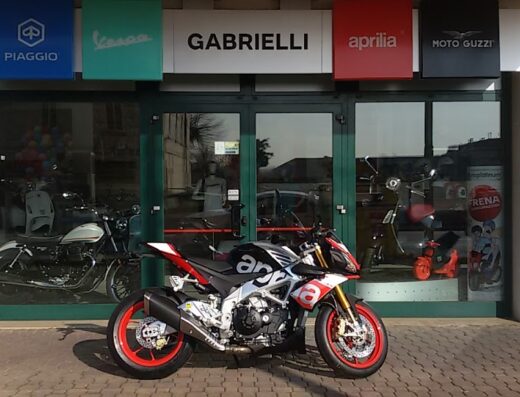 Gabrielli Moto Vicenza: Aprilia Tuono V4 in esposizione davanti alla concessionaria con cartelli Piaggio, Vespa, Aprilia e Moto Guzzi.