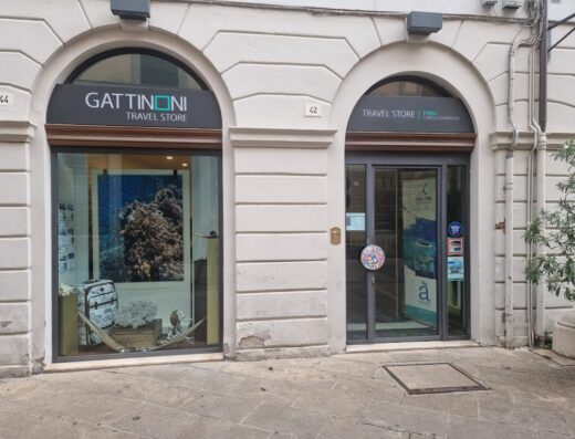 Gattinoni Travel Store Forlì: facciata esterna del negozio di viaggi con vetrina decorata a tema marino e ingresso su Corso Garibaldi.
