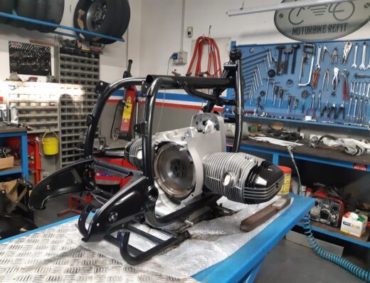 Telaio e motore di una moto BMW in riparazione in un'officina specializzata in restauro e personalizzazione di moto d'epoca. Servizi di riparazione, manutenzione e accessori moto.