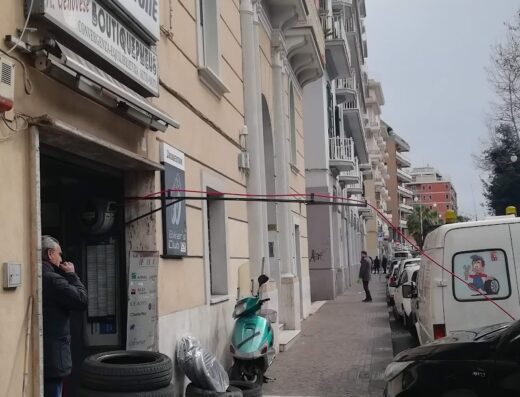 Negozio di pneumatici moto e scooter Genovese Antonio con insegna Keypoint Pirelli, copertoni impilati e scooter parcheggiato sul marciapiede.