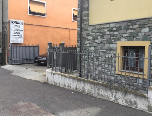 Autoriparazioni Giovinazzo, centro collaudi e revisione veicoli ad Aosta, con cartello indicante i servizi offerti: tagliandi certificati, ricarica aria condizionata, diagnosi centraline, e recapito telefonico.