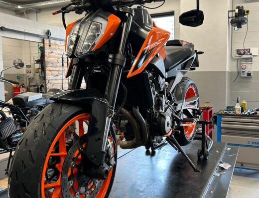 Una motocicletta KTM 790 Duke arancione e nera su un cavalletto in un'officina di riparazione moto. Servizi di manutenzione e riparazione per motociclette nel marketplace Giromoto.
