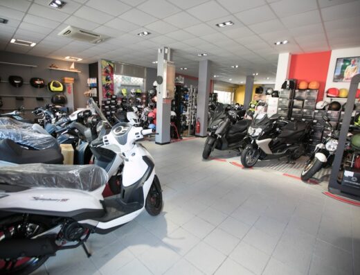 Interno del negozio GM Motor a Rapallo, rivenditore autorizzato Honda e Yamaha, con esposizione di scooter, moto e caschi.