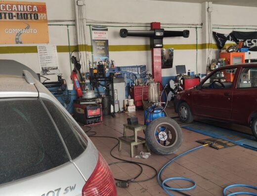 Interno dell'officina Gommauto di Gualtieri Corrado con attrezzature per la riparazione di auto e moto, ponte sollevatore, pneumatico e auto in riparazione.