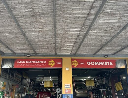 Foto di un gommista, Casu Gianfranco rivenditore autorizzato Momo Tires, con veicoli in riparazione e pneumatici in esposizione.