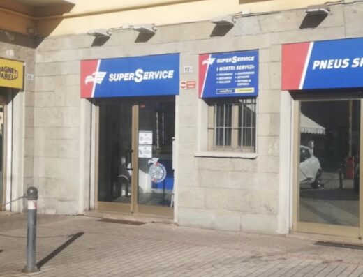 Pneus Sport gommista a Bologna, vetrina del negozio con insegne Super Service e Magneti Marelli per la riparazione e sostituzione di pneumatici moto e auto.