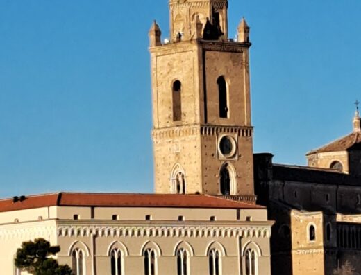 Grande Albergo Abruzzo: Dettaglio architettonico del campanile e dell'edificio storico con finestre ad arco, simbolo del patrimonio culturale abruzzese.