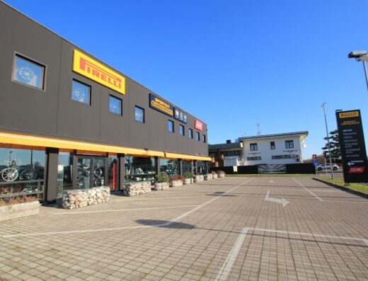 Veduta esterna dell'edificio di Guglielmi Sportkit con insegne Pirelli, che offre servizi per moto come riparazione, accessori e vendita di pneumatici.
