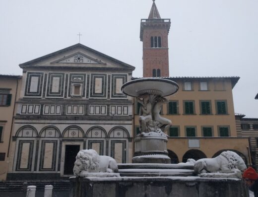 Basilica di San Lorenzo e fontana innevate, Firenze: architettura rinascimentale, sculture di leoni e torre campanaria sotto la neve.