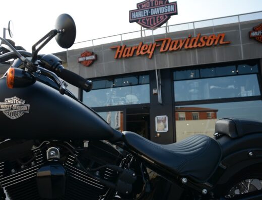 Harley-Davidson nera parcheggiata di fronte alla concessionaria a Pavia, con logo ben visibile sul serbatoio. Accessori moto e dettagli del design in primo piano.