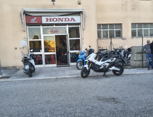 Honda Center storefront with various Honda motorcycles parked outside, showcasing the latest models and services.