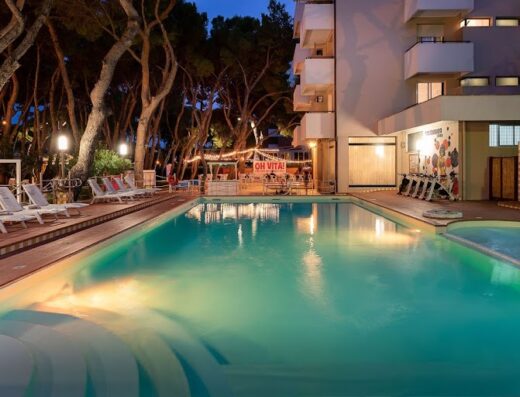 Hotel Baltic piscina esterna illuminata di sera con lettini e area bar sullo sfondo, ideale per relax e vacanza