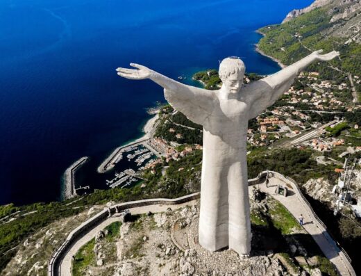 Statua del Cristo Redentore di Maratea, imponente scultura con vista panoramica sulla costa, il porto turistico e il mare cristallino della Basilicata, Italia.