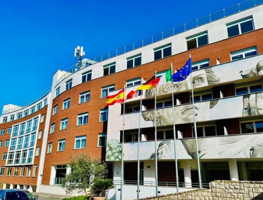Hotel Capannelle exterior featuring flags of Spain, Germany, Italy, and the European Union, with a mural of Michelangelo's David.