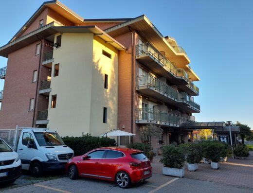 Hotel Davide: Facciata esterna dell'hotel con balconi, parcheggio con auto e furgone. Servizi e accoglienza per motociclisti in viaggio.