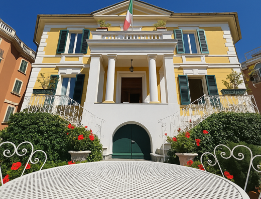 Hotel delle Rose: Facciata esterna dell'hotel con bandiera italiana, tavolo da esterno, verde curato e architettura tipica.