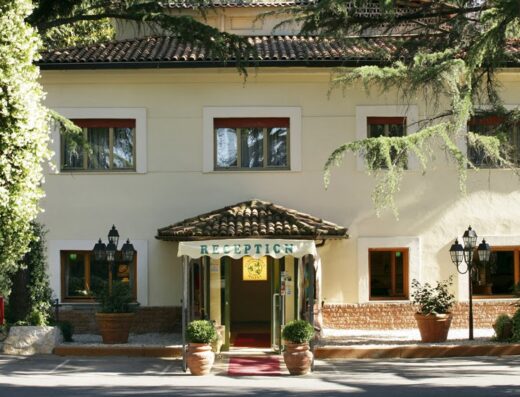 Hotel Eurogarden reception area, featuring the entrance with a 'Reception' awning, potted plants, and classic outdoor lighting.