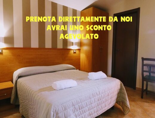 Camera da letto accogliente all'Hotel La Suite, con letto matrimoniale, comodino, armadio e sedia. Prenota direttamente per uno sconto!