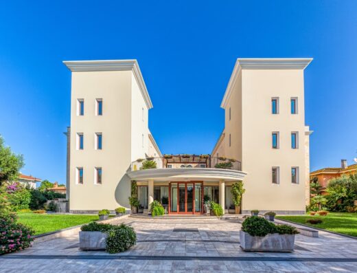 Hotel Le Torri, vista frontale dell'ingresso principale con architettura a due torri e giardino curato, ideale per un soggiorno rilassante.