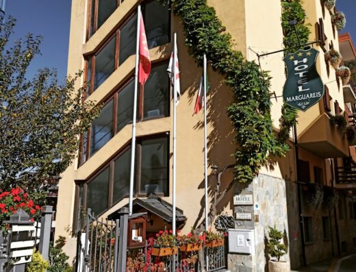 Esterno dell'Hotel Marguareis con bandiere, insegna e decorazioni floreali, ideale per viaggi in moto e relax.