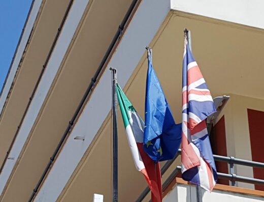 Bandiere italiana, europea e britannica sventolano all'Hotel Nola Maddaloni 4 stelle, simbolo di accoglienza internazionale e servizi di alta qualità.